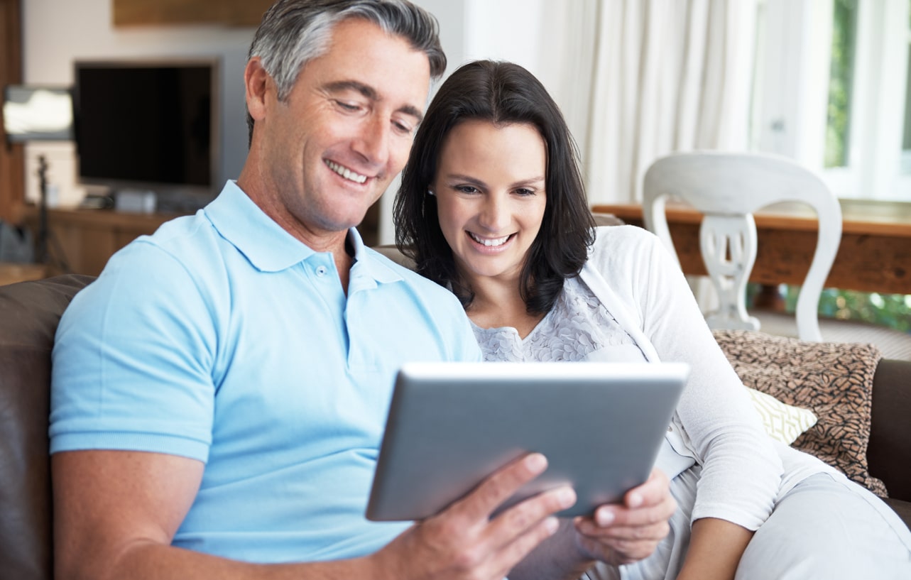 Collagen sitting on sofa and making online purchase on ipad